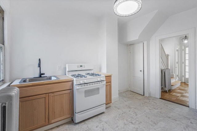 kitchen featuring radiator heating unit, sink, and white gas range oven