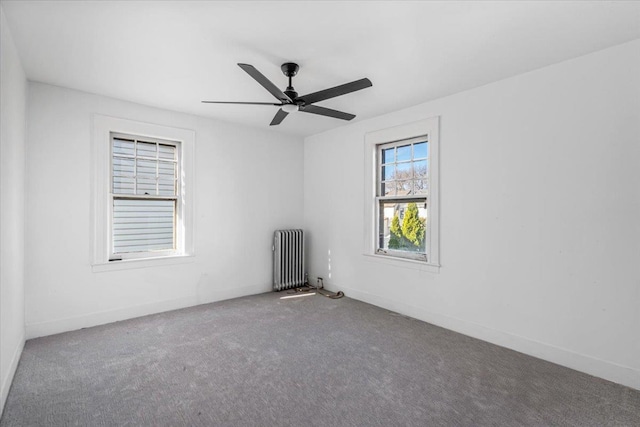 carpeted spare room featuring radiator and ceiling fan