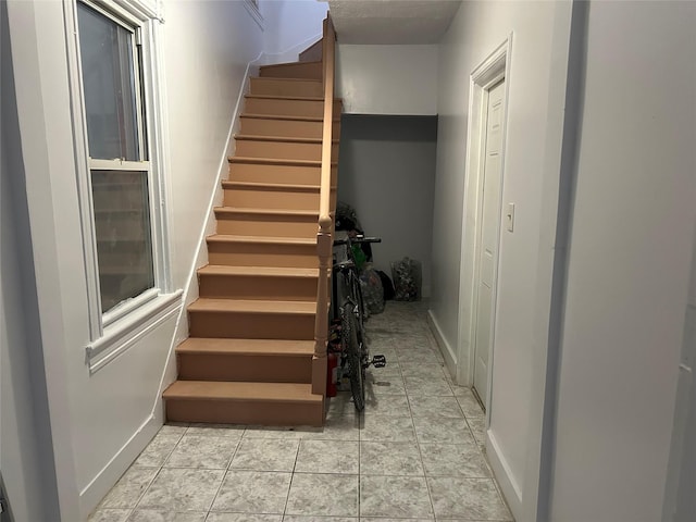 stairway with tile patterned floors