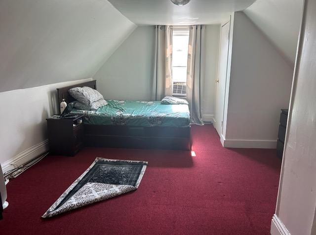 carpeted bedroom featuring lofted ceiling