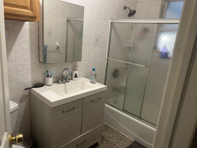 full bathroom with backsplash, toilet, tile walls, and combined bath / shower with glass door