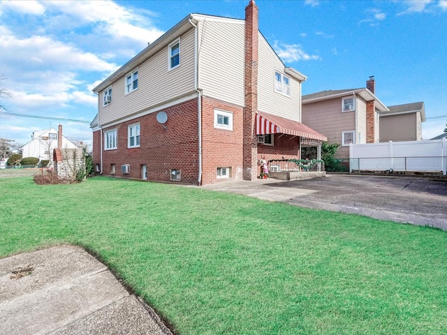 rear view of house featuring a patio area and a yard