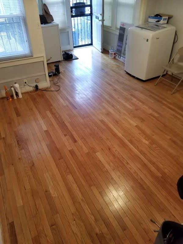 interior space featuring hardwood / wood-style floors, fridge, and washer / dryer