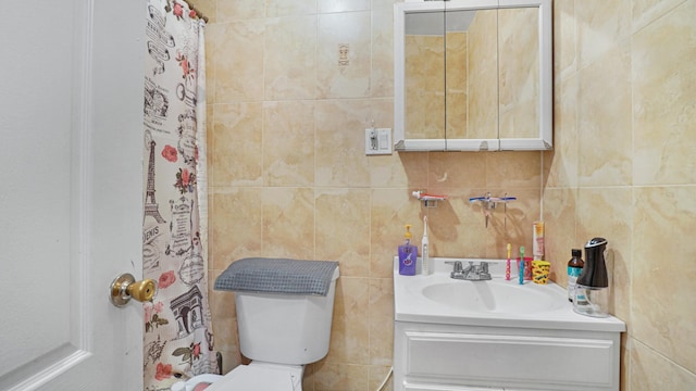 bathroom featuring vanity, toilet, and tile walls