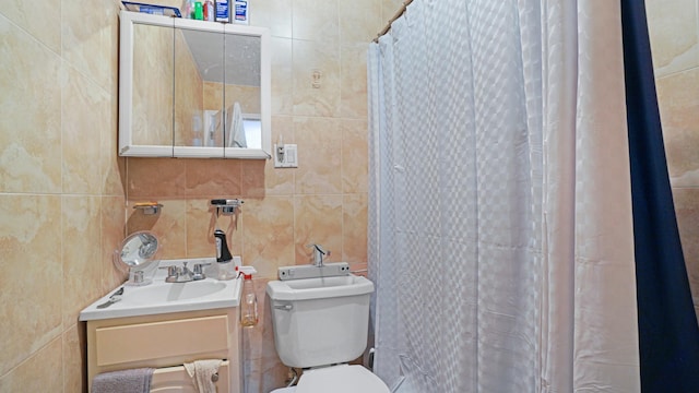 bathroom with vanity, toilet, and tile walls