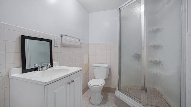 bathroom featuring tile patterned floors, walk in shower, vanity, tile walls, and toilet