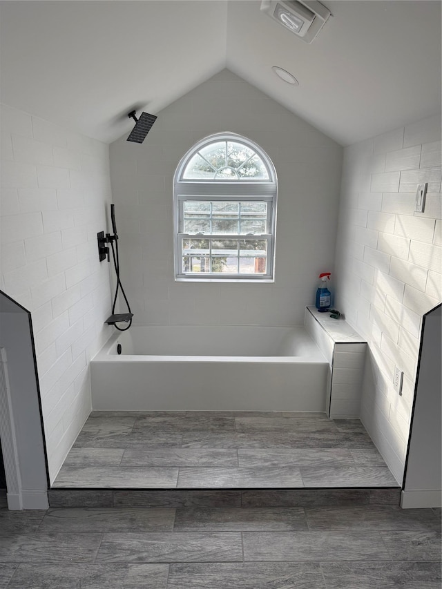 bathroom featuring separate shower and tub and vaulted ceiling