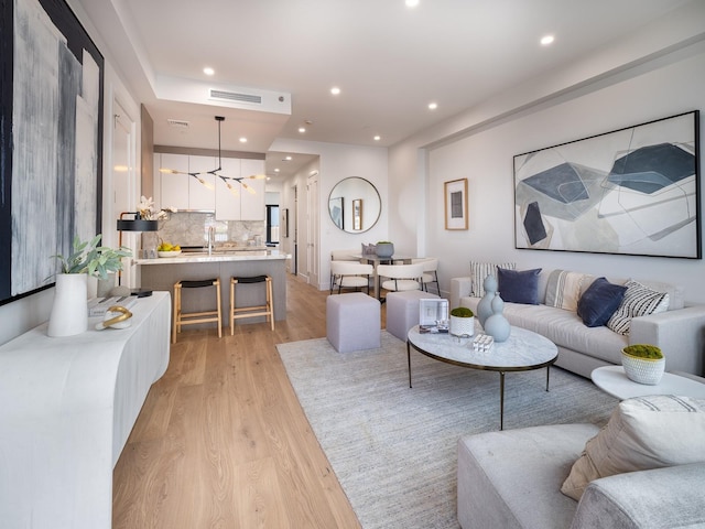 living room featuring light wood-type flooring and sink