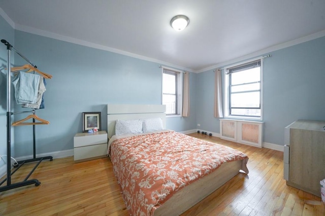 bedroom with crown molding and light wood-type flooring