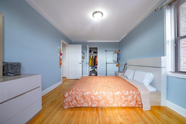 bedroom with crown molding, a closet, and hardwood / wood-style floors