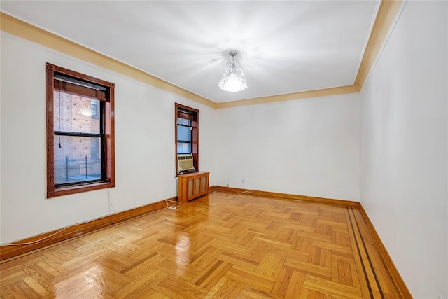 empty room with a notable chandelier, cooling unit, crown molding, and light parquet flooring