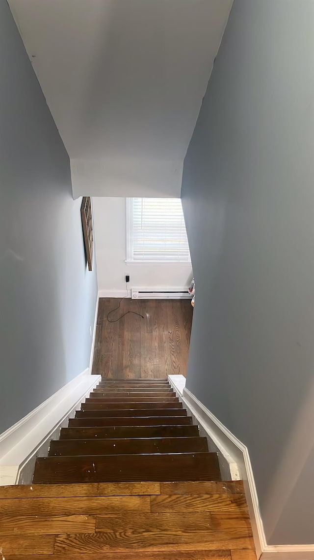 staircase featuring a baseboard heating unit