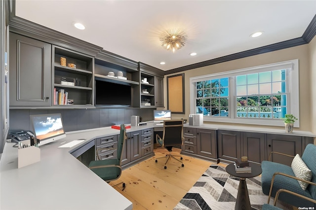 office area with ornamental molding, built in desk, and light hardwood / wood-style flooring