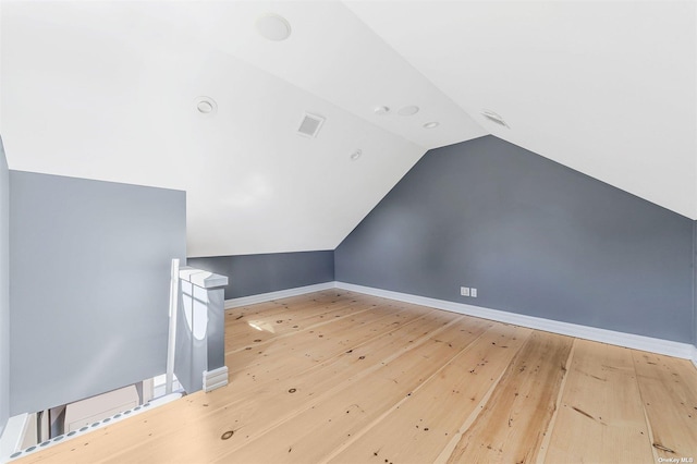 additional living space with lofted ceiling and hardwood / wood-style floors