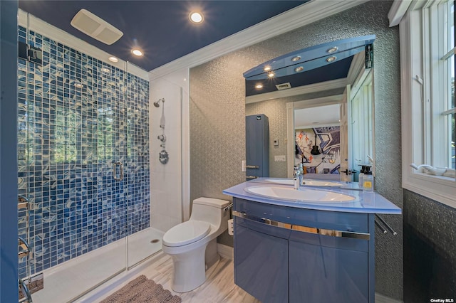 bathroom featuring a wealth of natural light, an enclosed shower, vanity, toilet, and crown molding