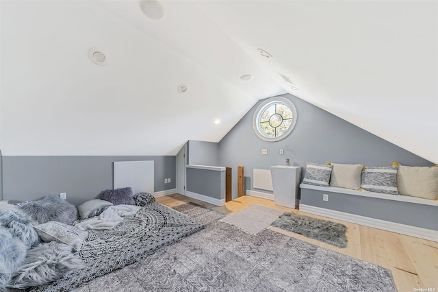 bedroom with light wood-type flooring and vaulted ceiling