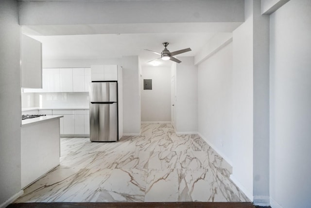 kitchen featuring white cabinets, electric panel, stainless steel refrigerator, and ceiling fan