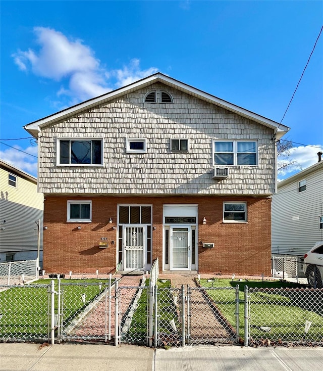 view of front of home featuring a fenced front yard, a gate, brick siding, and a front lawn