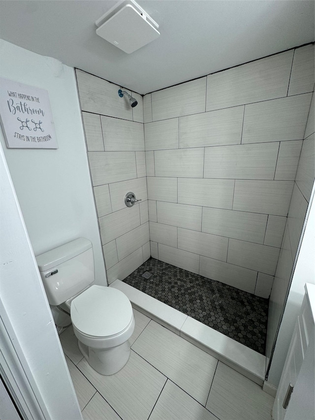 bathroom with tiled shower and toilet