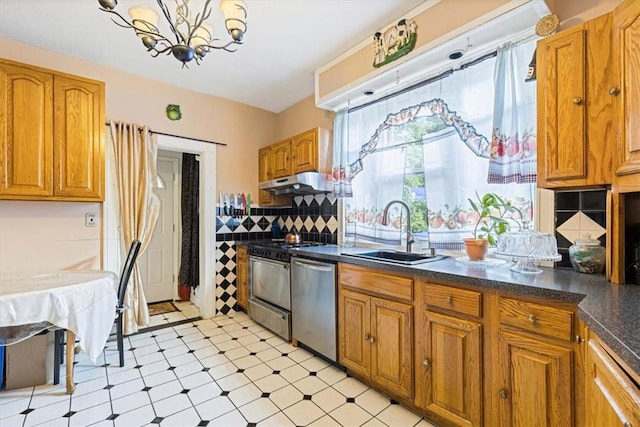 kitchen with backsplash, sink, appliances with stainless steel finishes, and an inviting chandelier