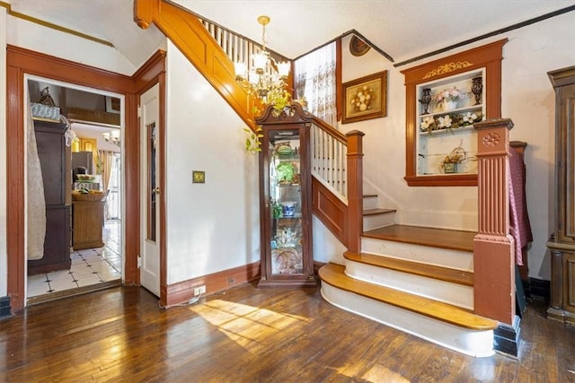 stairway featuring a notable chandelier, wood-type flooring, and ornamental molding