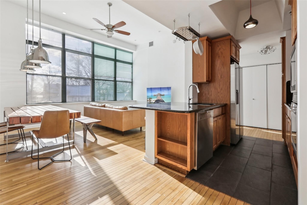 kitchen with refrigerator with ice dispenser, stainless steel dishwasher, hanging light fixtures, and sink