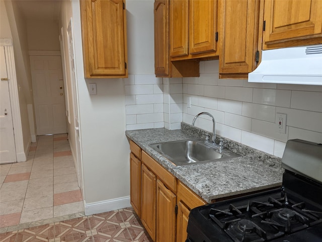 kitchen with black gas range, sink, tasteful backsplash, range hood, and light tile patterned flooring