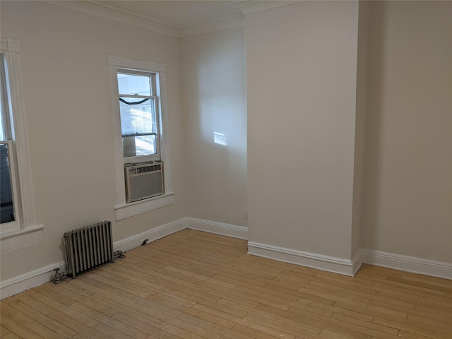 spare room featuring radiator heating unit, light hardwood / wood-style floors, cooling unit, and crown molding