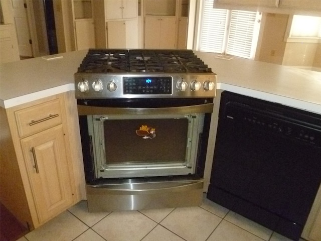 interior details featuring dishwasher, high end stove, and light brown cabinetry