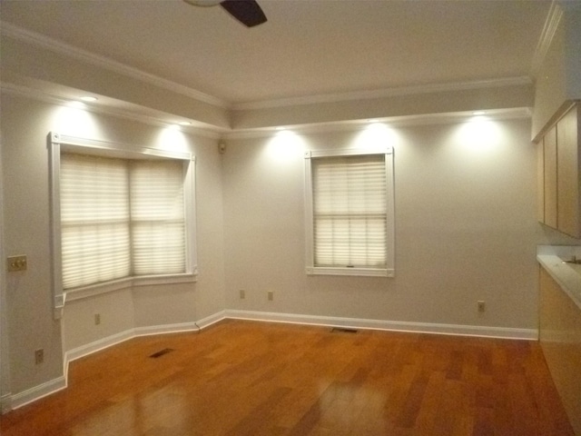 spare room featuring crown molding, wood-type flooring, and ceiling fan