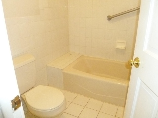 bathroom featuring toilet, tile patterned flooring, and tile walls