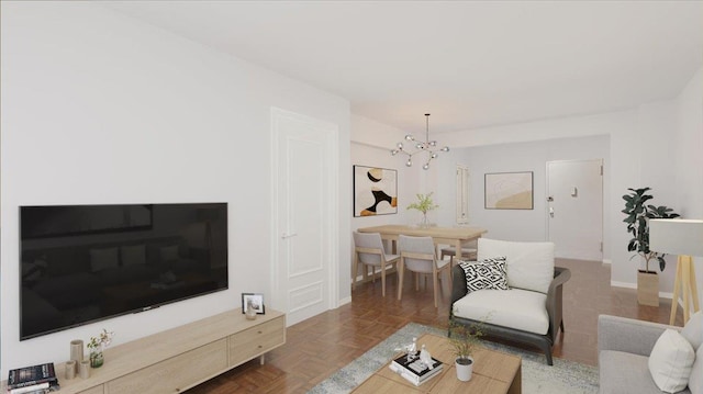 living room featuring dark parquet flooring and an inviting chandelier