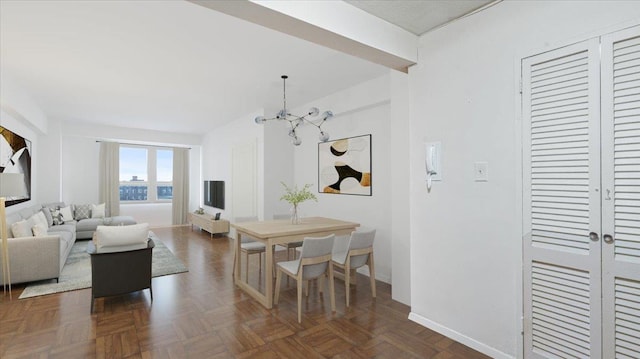 dining space with dark parquet flooring and an inviting chandelier