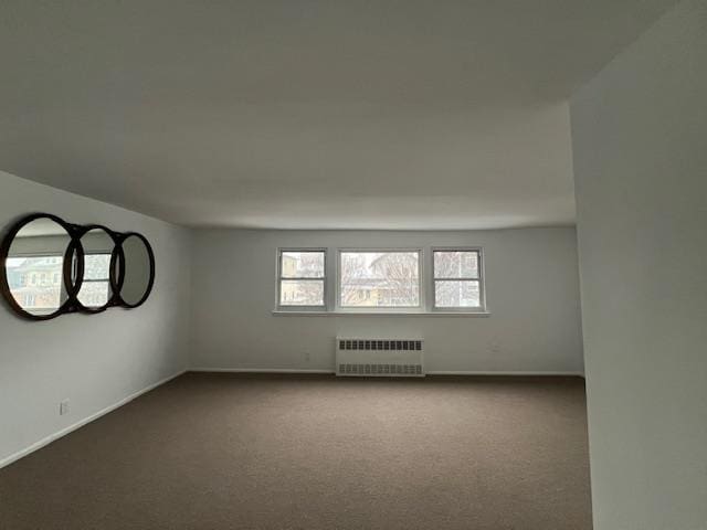 carpeted spare room with radiator heating unit