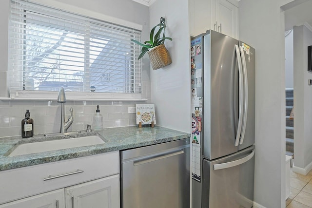 kitchen with white cabinetry, appliances with stainless steel finishes, sink, and backsplash