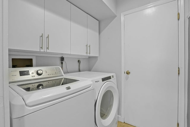 laundry area featuring washer and clothes dryer and cabinets