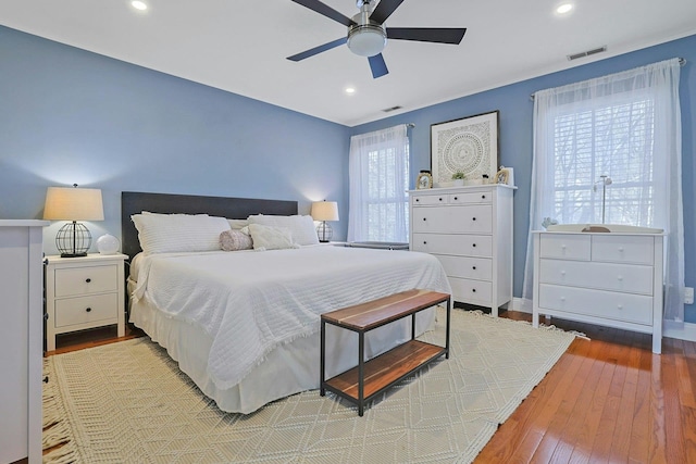 bedroom featuring ceiling fan, multiple windows, and light wood-type flooring