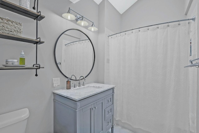 bathroom with vanity, vaulted ceiling, and toilet