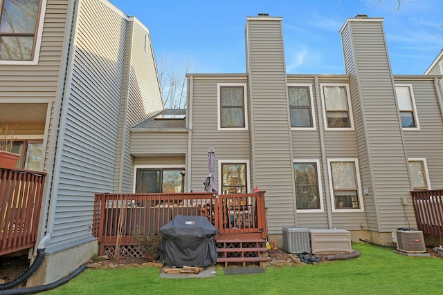 rear view of house with a wooden deck, a yard, and central AC