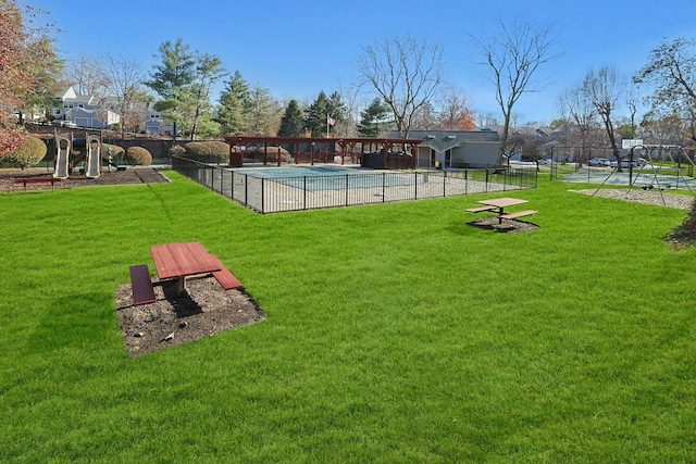 view of yard featuring a community pool and basketball hoop