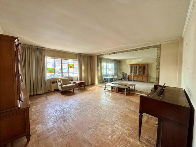 living area featuring light parquet flooring, radiator, and ornamental molding