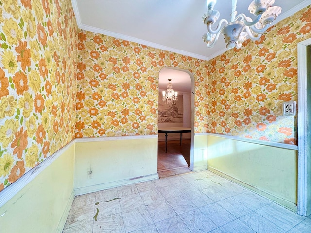 spare room featuring an inviting chandelier and ornamental molding