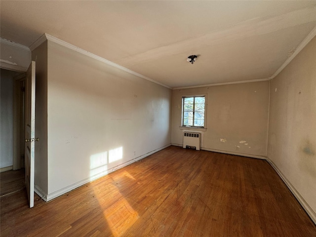 empty room featuring hardwood / wood-style flooring, radiator heating unit, and crown molding