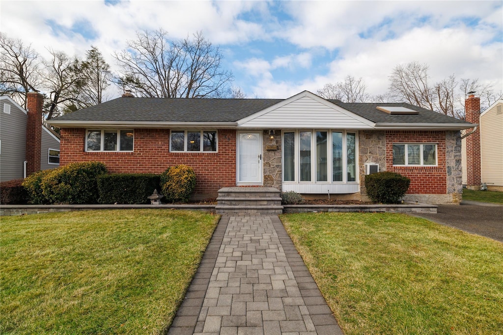 view of front of property featuring a front yard and a sunroom