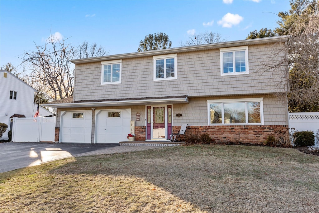 view of property with a garage and a front lawn