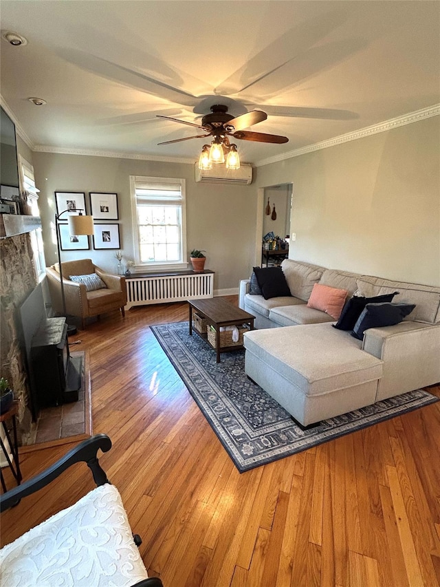 living room featuring a wall mounted air conditioner, radiator heating unit, crown molding, ceiling fan, and wood-type flooring