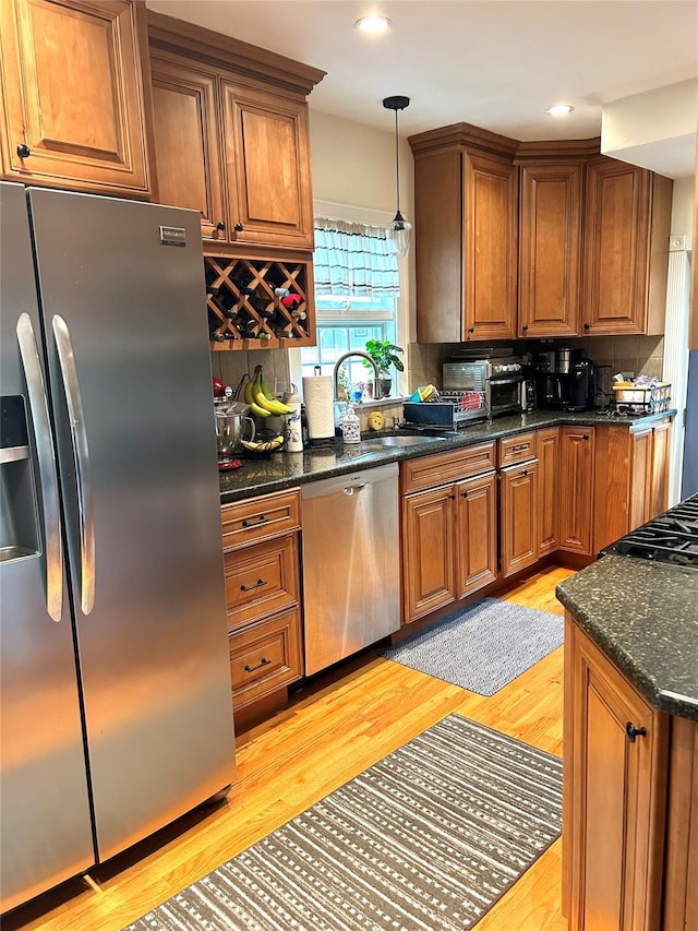 kitchen with decorative backsplash, sink, stainless steel appliances, and light hardwood / wood-style floors