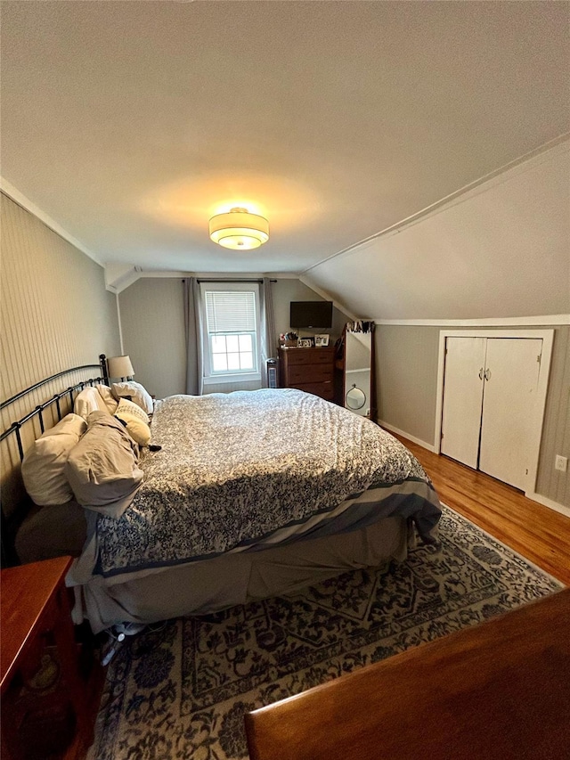 bedroom featuring hardwood / wood-style flooring, lofted ceiling, and a textured ceiling