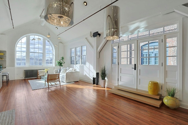 entryway featuring radiator, vaulted ceiling, hardwood / wood-style floors, and ceiling fan