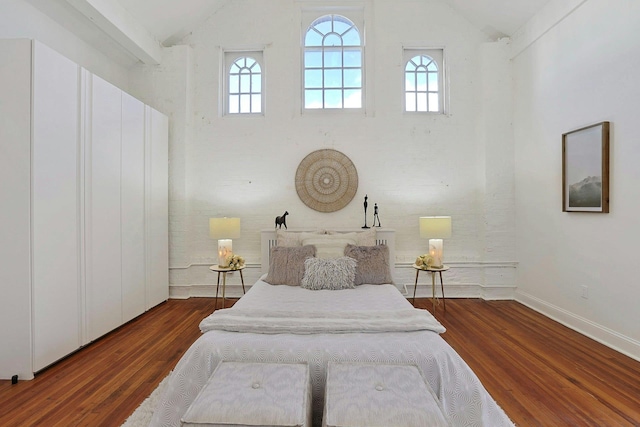 bedroom featuring lofted ceiling and dark hardwood / wood-style floors